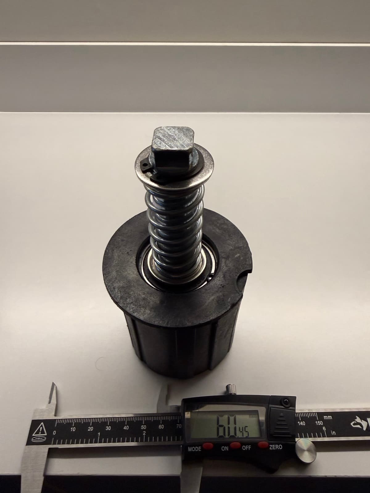 Digital caliper measuring an idler assembly during verification sample inspection