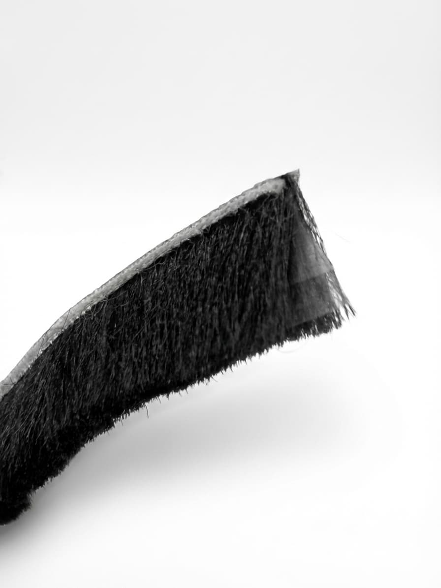 Double-fin brush seal strip with black bristles on white studio background